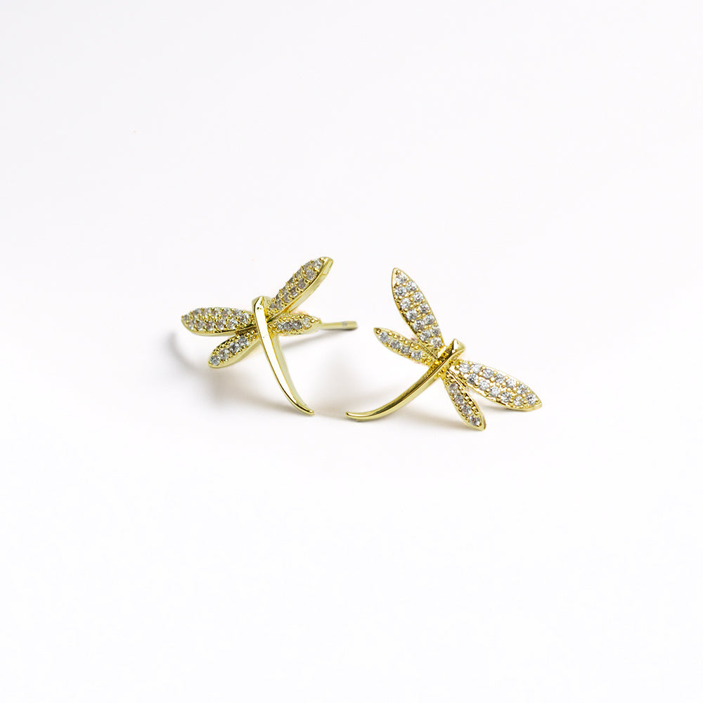 Pair of gold dragonfly earrings with a white backdrop
