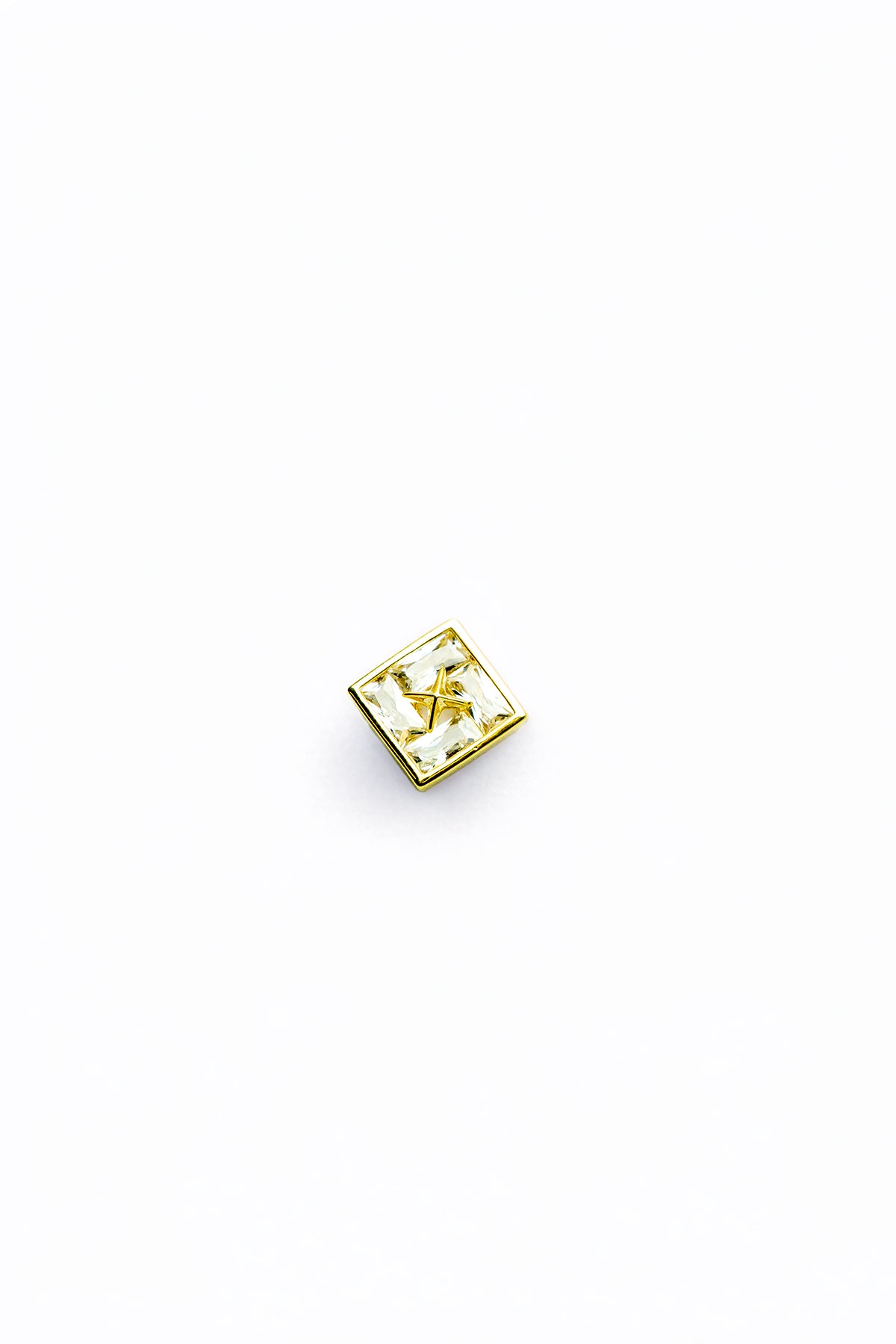 Single gold-tone stud earring close-up